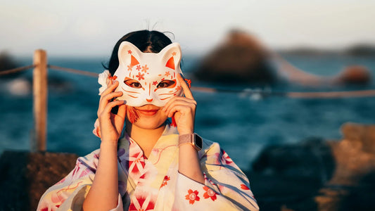 Femme en kimono portant un masque kitsune, symbole du folklore japonais représentant le renard spirituel.