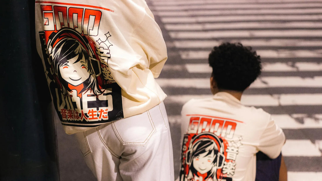 Deux jeunes portant un sweat manga blanc avec un design graphique coloré dans une rue urbaine de nuit.