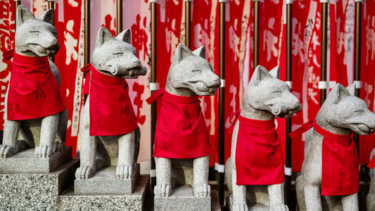 Statues de renards Inari dans un sanctuaire shinto au Japon, symbole de protection et de prospérité.