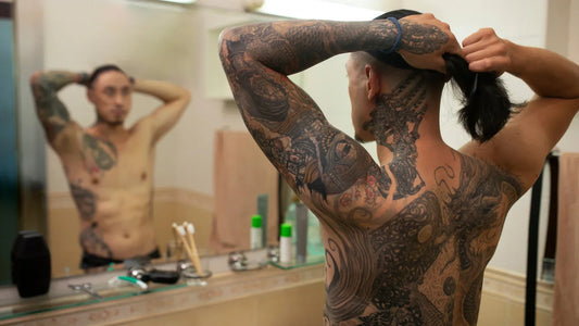 Homme avec des tatouage japonais traditionnel représentant des dragons et des motifs mythologiques.