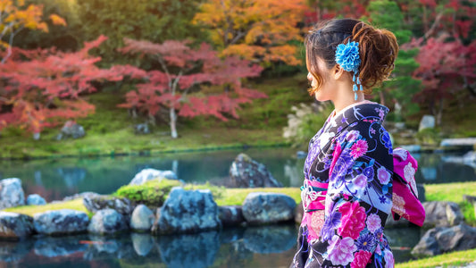 Femme en kimono traditionnel contemplant un jardin japonais avec étang et érables d’automne, représentant l’esprit zen dans la culture japonaise moderne.