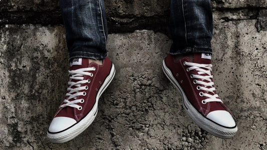 Paire de sneakers rouges portées avec un jean, représentant le style urbain japonais et l’influence streetwear dans la mode contemporaine.