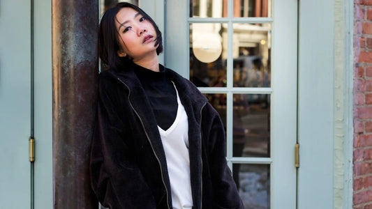 Femme au look urbain chic portant une veste oversize et un haut blanc, illustrant l’élégance minimaliste et moderne de la mode japonaise.
